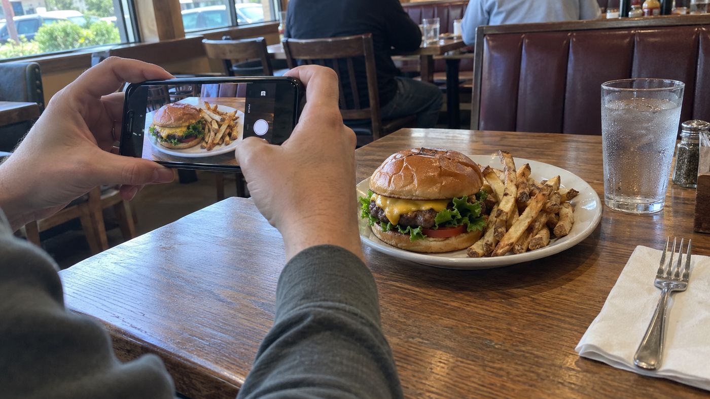 A diner photographing a meal to share